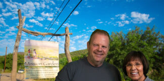 Tom Heath and Alyce Sadongei standing in front of the Mission Garden welcome sign in Tucson, Arizona.