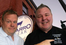 Gary Hickey – A Tucson Story of Resilience, Kindness, and Community Life Along the Streetcar host pointing to the embroidered name on a guest’s Charro Steak chef coat outside the downtown Tucson restaurant.
